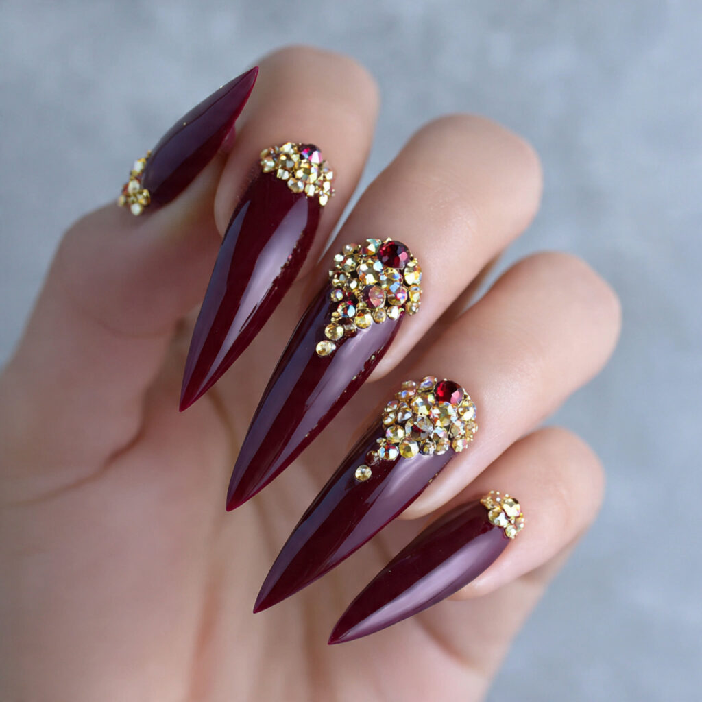 deep wine stiletto with gold rhinestones nails