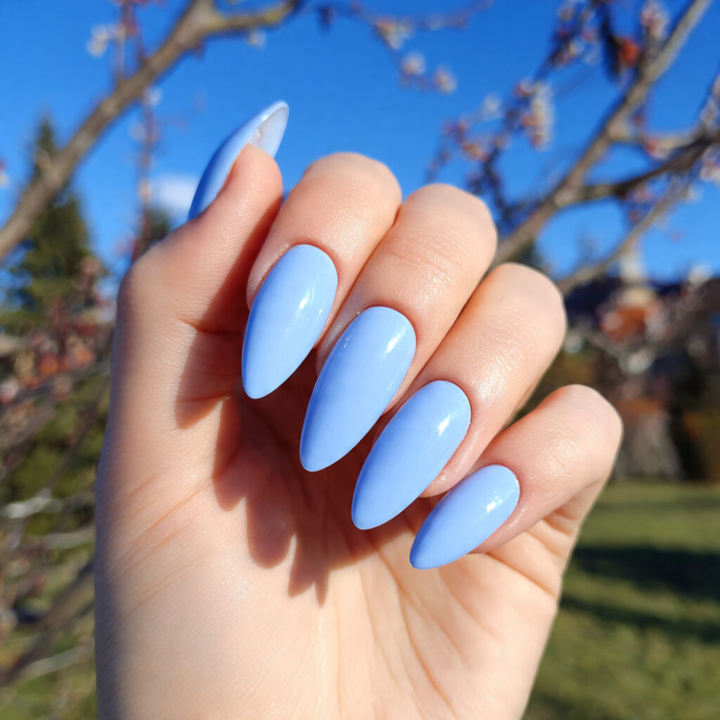 attractive baby blue glossy nails with outdoor bac