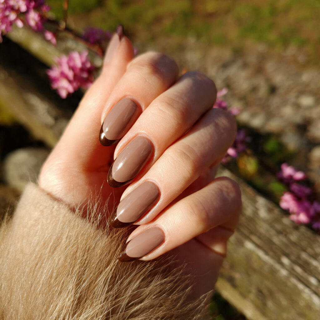 attractive brown tip almond nails with outdoor bac