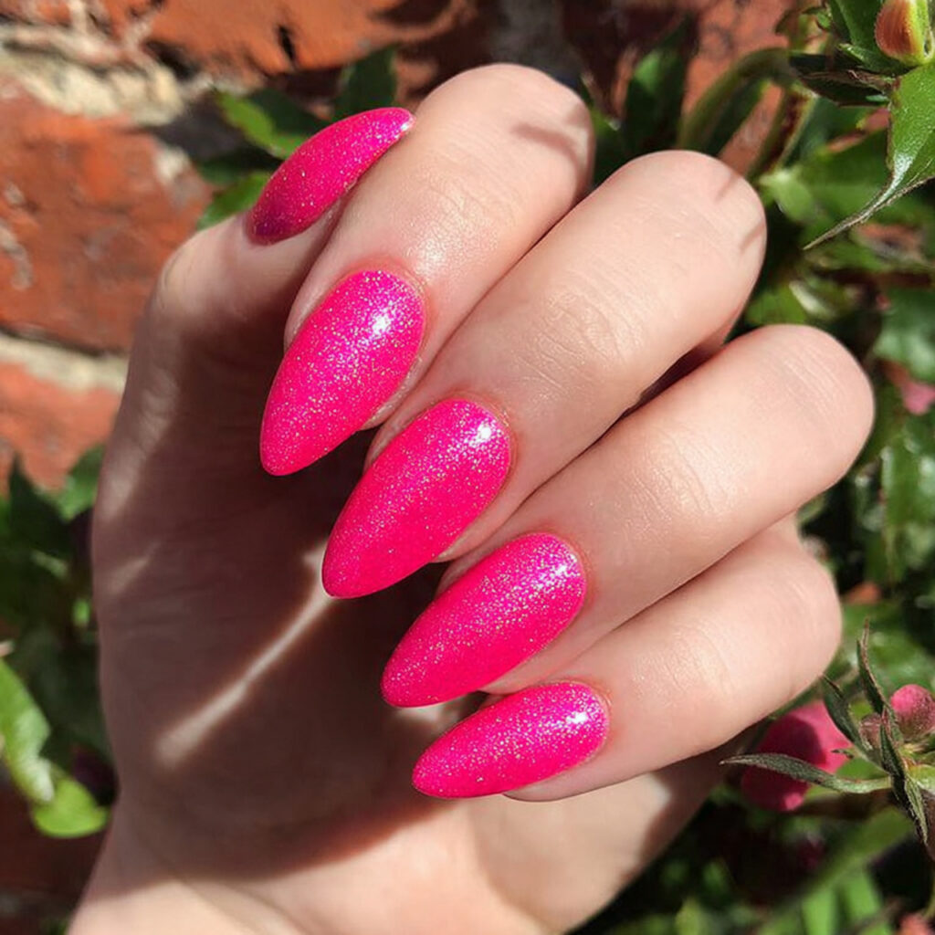 attractive neon pink shimmer nails with outdoor ba