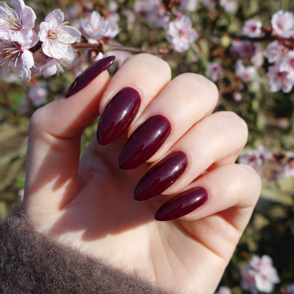 attractive deep burgundy almond nails with outdoor
