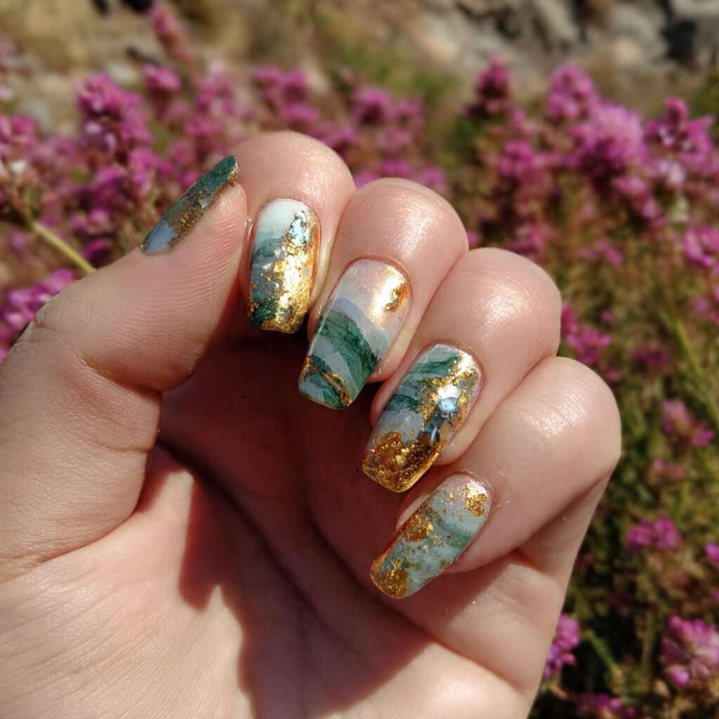 Nail Inspo Maximalist: Bold, Extra & Unapologetically Glam 6 attractive gold foil gem nails with outdoor backgr