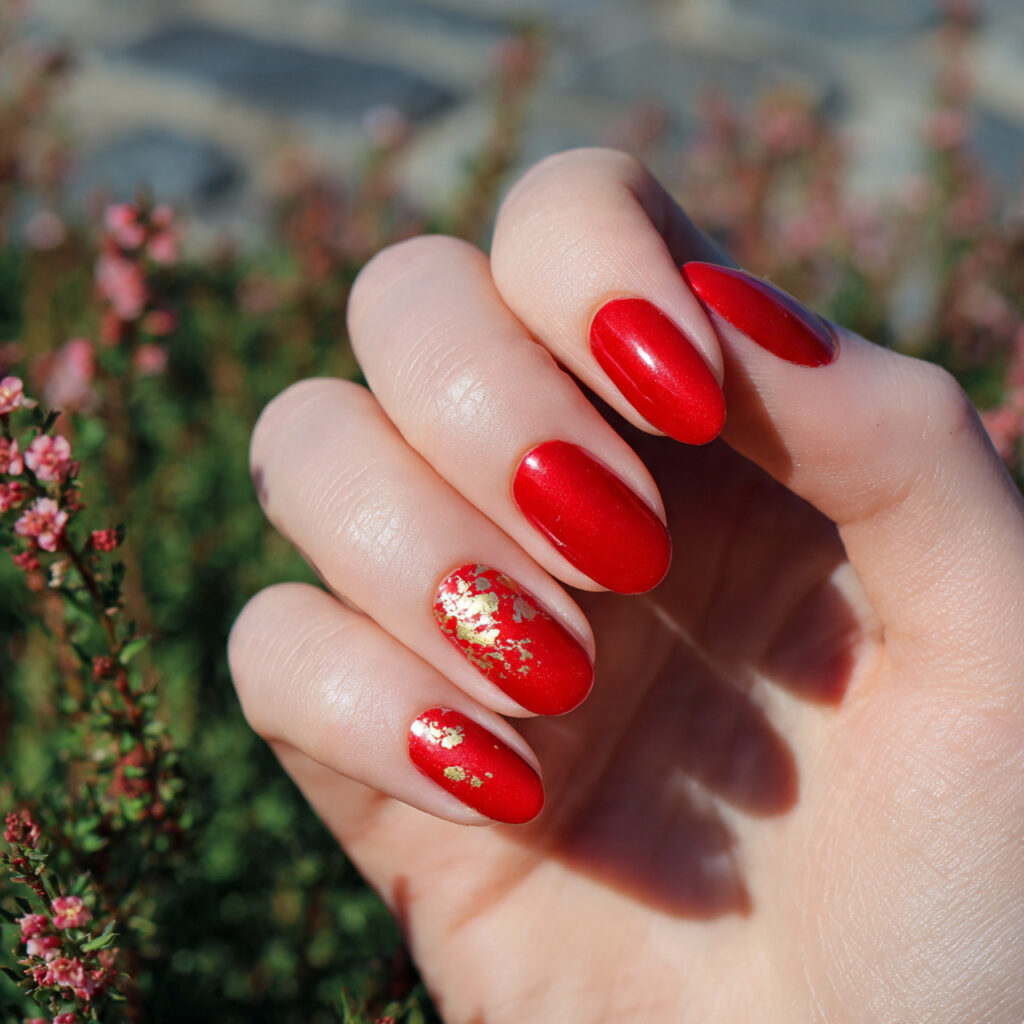 Red Gold Nails: Luxe, Fiery Designs That Feel Instantly Iconic 1 attractive hand with classic red nails featuring g