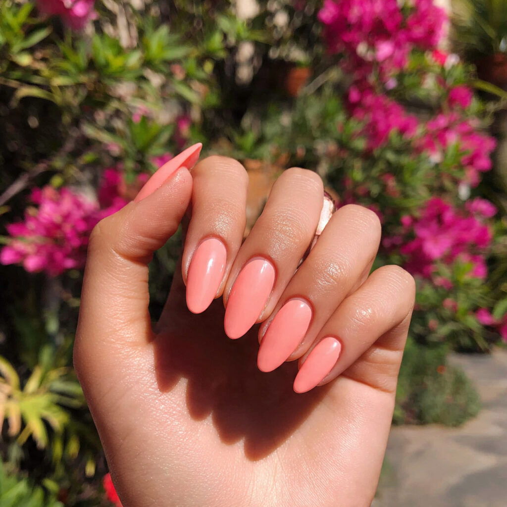 attractive peachy pink almond nails with outdoor b