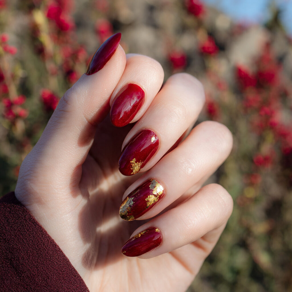Red Nails With Gold: The Luxe, Glowing Combo You’ll Be Obsessed With 1 close up of one hand with cherry red nails featuri