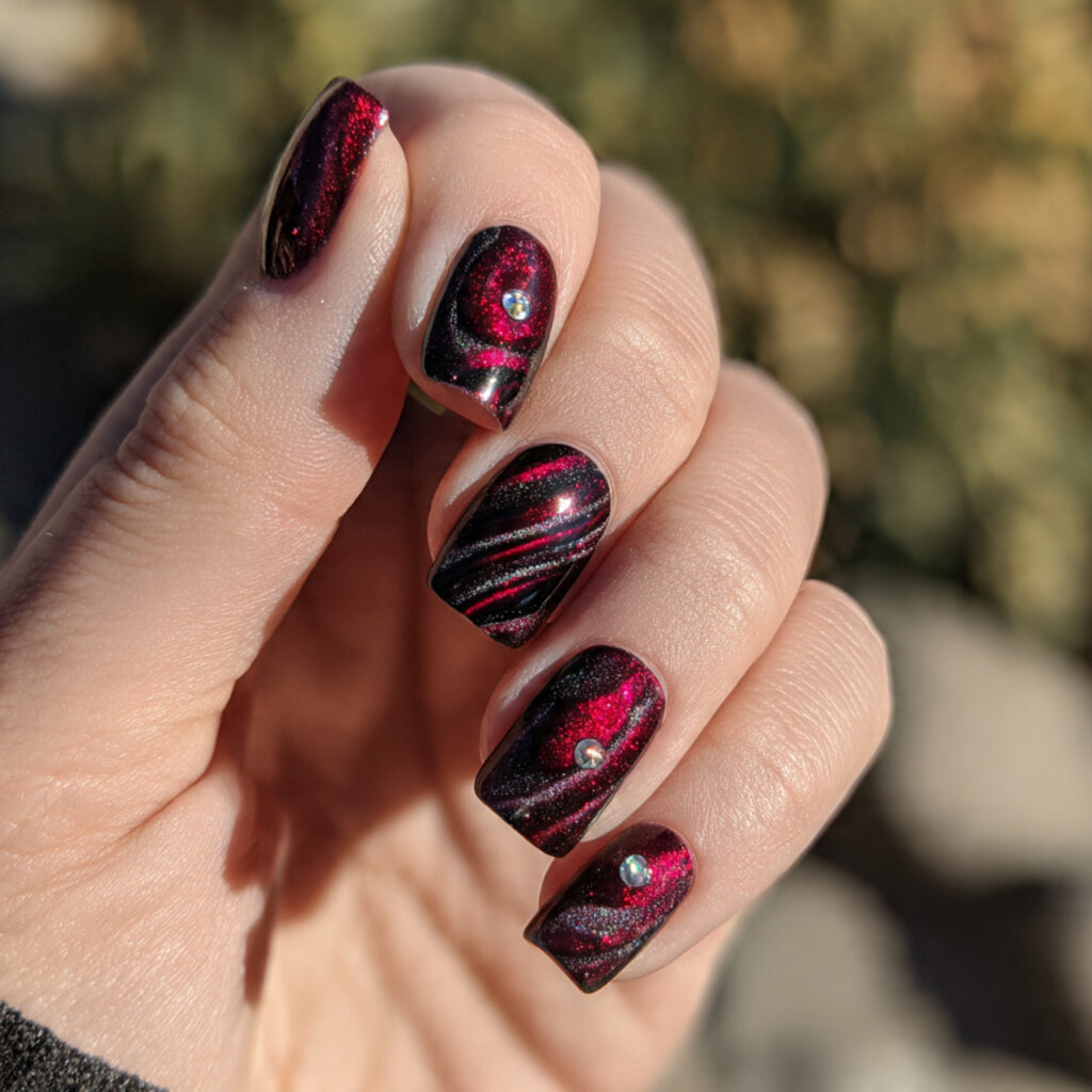 Red Nails Cat Eye: Magnetic Glow You Can’t Stop Staring At 14 close up of one hand with dark red galaxy cat eye