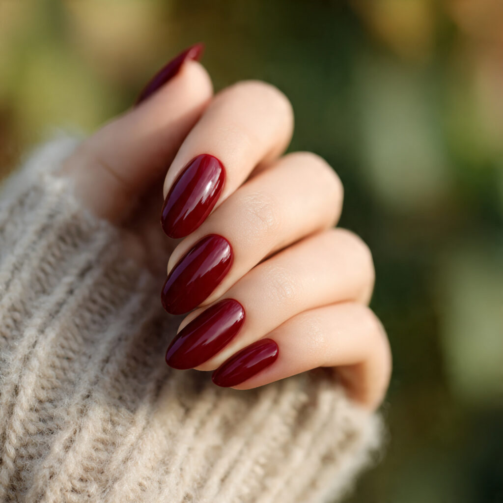 Classic Red Nails: Timeless, Elegant & Always in Style 2 close up of one hand with deep wine red almond sha 1