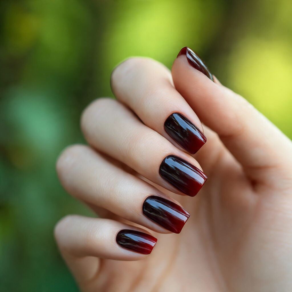 one hand with attractive black dark red ombre nail
