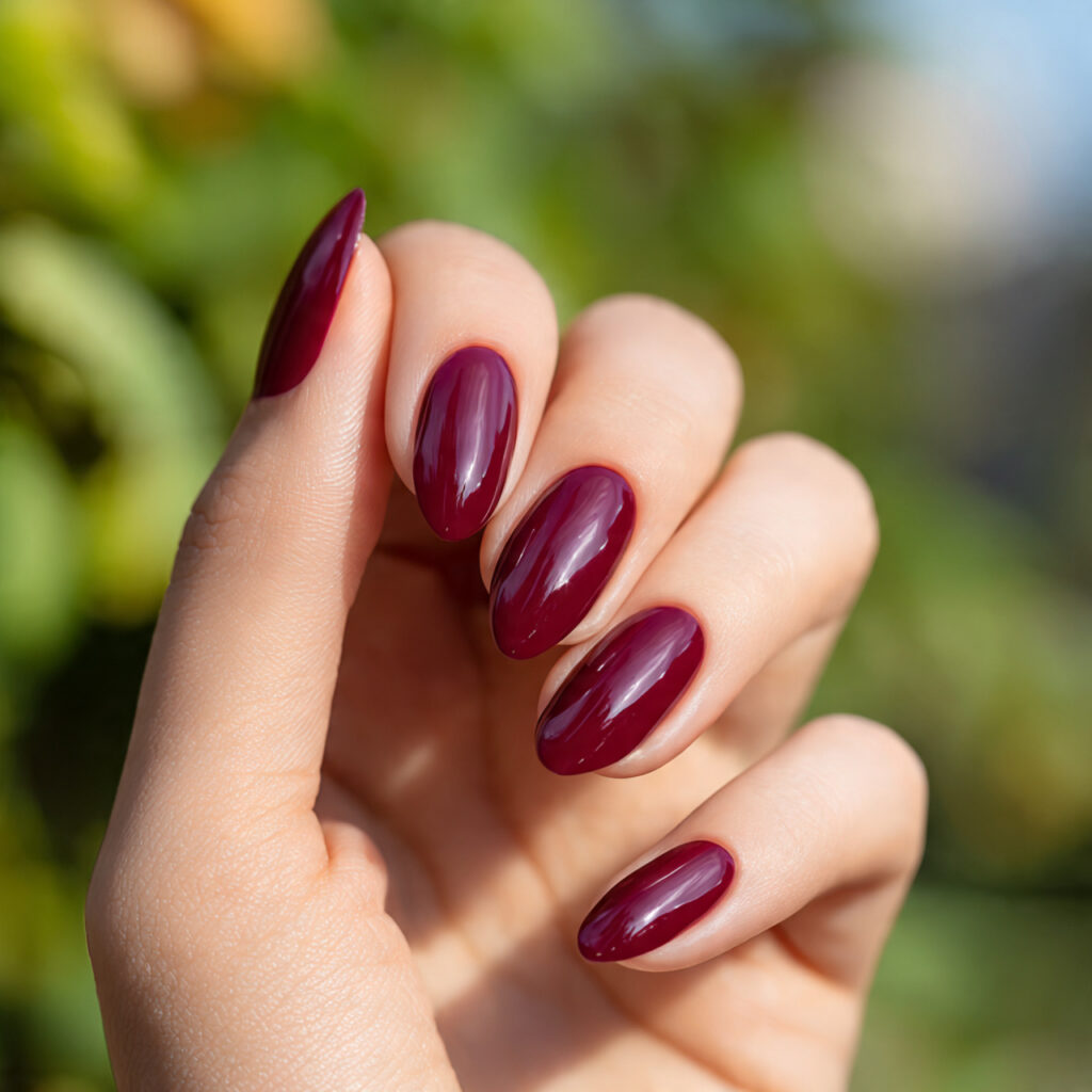 one hand with attractive burgundy mix nails glossy
