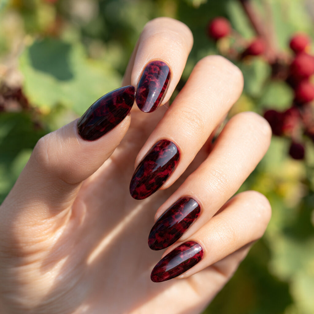 one hand with attractive dark red swirl nails glos