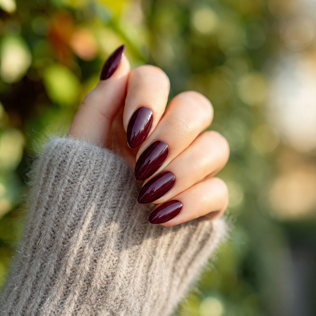 Red Nails Inspo 2026: Bold, Glossy & Totally Addictive Looks 2 one hand with deep burgundy almond shaped nails cl